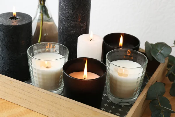 Bandeja con velas encendidas y ramas verdes en la mesa —  Fotos de Stock