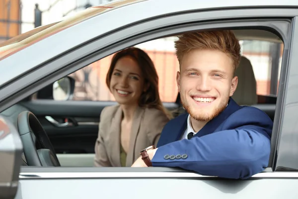 Happy young man and woman in modern car — Stock Photo, Image