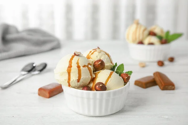 Delizioso gelato servito con caramello e nocciole serviti in tavola — Foto Stock