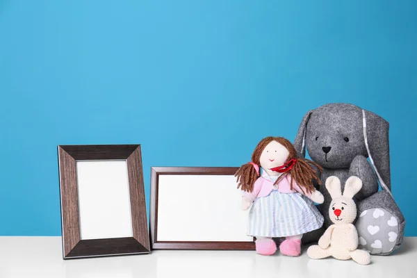 Marcos de fotos y juguetes adorables en la mesa contra el fondo de color, espacio para el texto. Elementos de habitación infantil — Foto de Stock