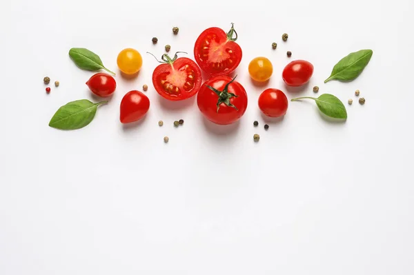 Composición con tomates cherry maduros y hojas de albahaca sobre fondo blanco, vista superior — Foto de Stock
