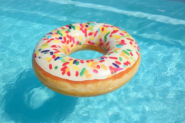 Jasny dmuchany pierścień pierścieniowy pływający w basenie w słoneczny dzień — Zdjęcie stockowe