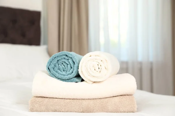 Soft clean terry towels on bed in room — Stock Photo, Image