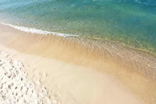 Θέα στο θαλασσινό νερό και την αμμώδη παραλία την ηλιόλουστη μέρα — Φωτογραφία Αρχείου