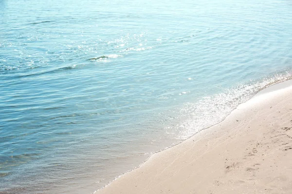 Θέα στο θαλασσινό νερό και την αμμώδη παραλία την ηλιόλουστη θερινή ημέρα — Φωτογραφία Αρχείου