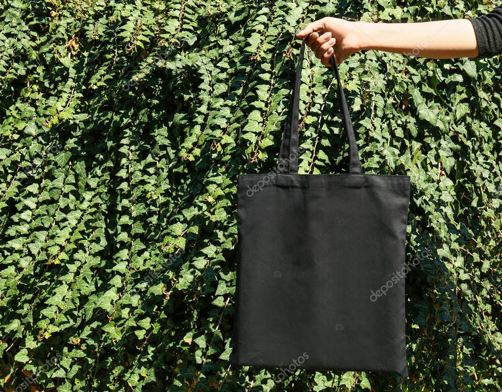 Woman holding eco bag outdoors, closeup. Mockup for design