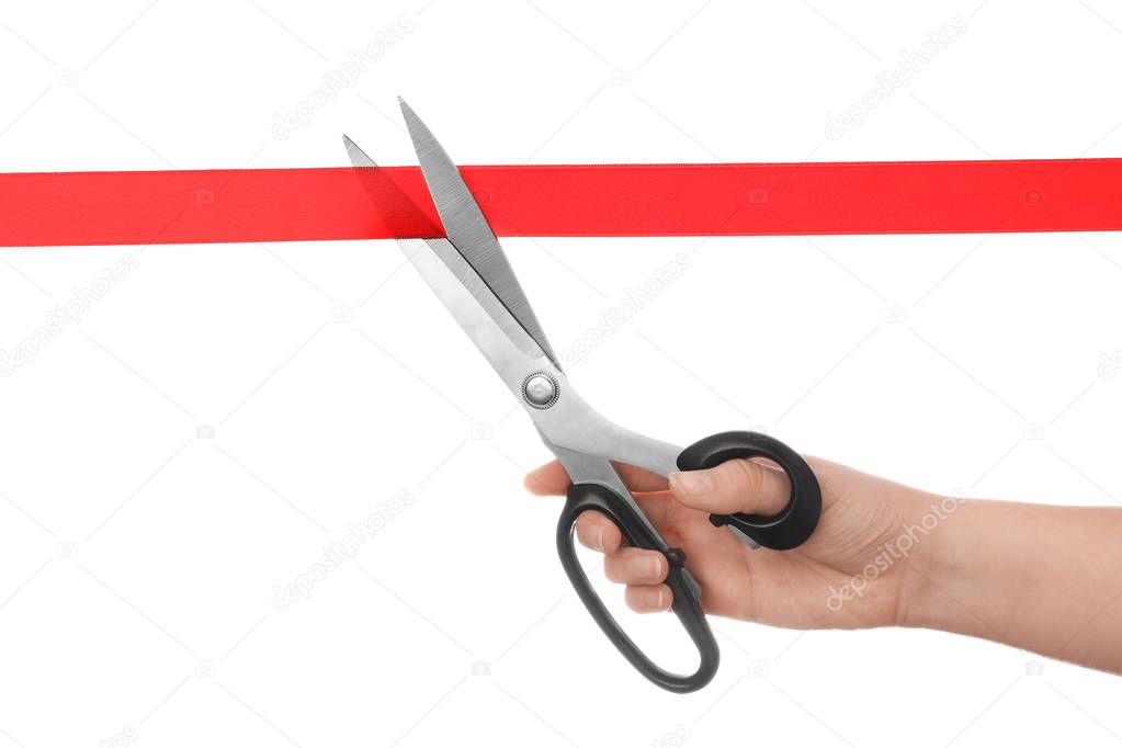 Woman cutting red ribbon with scissors on white background. Traditional ceremony