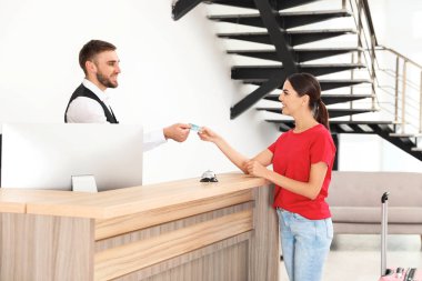 Modern otelde resepsiyonda müşteriile çalışan profesyonel resepsiyonist