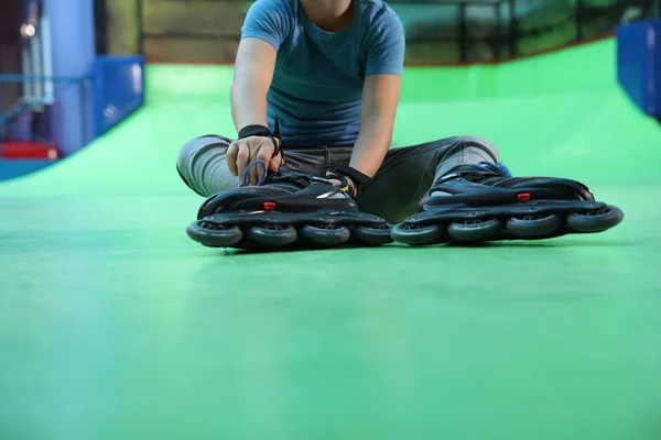 男孩与溜冰鞋坐在溜冰场 — 图库照片