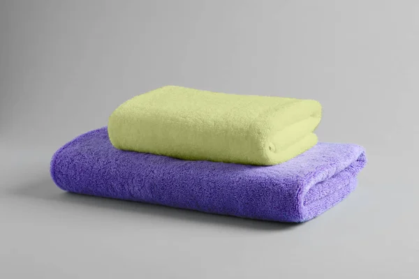 Diferentes toalhas terry macio no fundo cinza — Fotografia de Stock