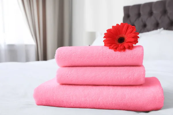 部屋のベッドの上の柔らかいテリータオルと花 — ストック写真