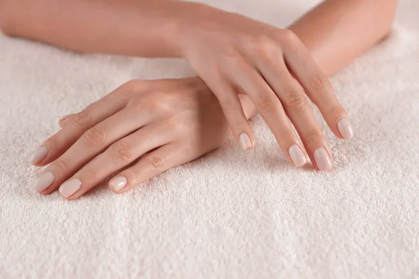 Donna con mani lisce e manicure su asciugamano, primo piano. Trattamento termale — Foto Stock