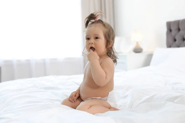 Godny podziwu mały dziecko dziewczyna siedzący na łóżko w Pokój — Zdjęcie stockowe