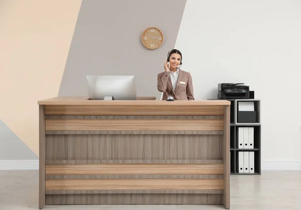 Retrato de la recepcionista trabajando en el escritorio en el hotel moderno —  Fotos de Stock