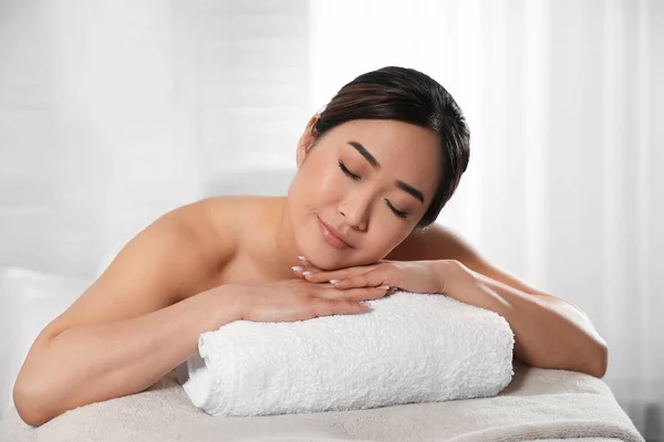 Belle asiatique femme couché sur massage table dans spa salon — Photo