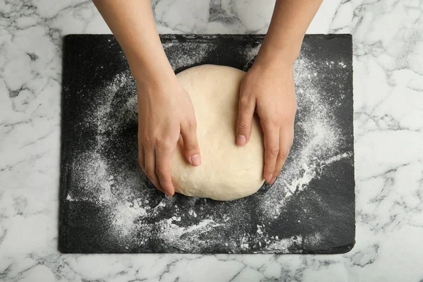 Assadeira feminina preparando massa de pão na mesa de mármore, vista superior — Fotografia de Stock