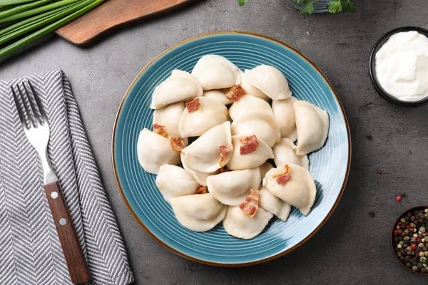 Placa de sabrosos dumplings cocidos servidos sobre la superficie de piedra, plano laico — Foto de Stock