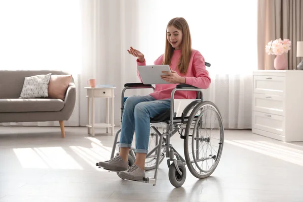 Tiener meisje in een rolstoel met behulp van video chat op Tablet thuis — Stockfoto