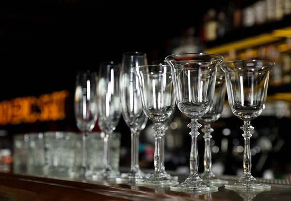 Diferentes vidros limpos vazios no balcão no bar — Fotografia de Stock