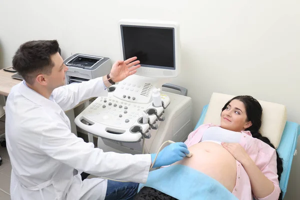 Νεαρή έγκυος γυναίκα, που υποβάλλονται σε υπερηχογράφημα στο ιατρείο — Φωτογραφία Αρχείου