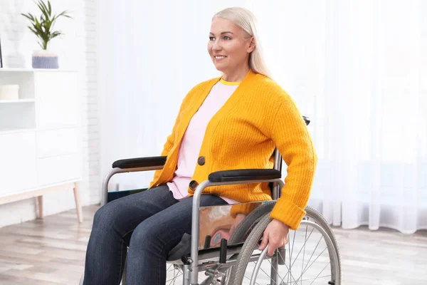 Rijpe vrouw zittend in een rolstoel thuis — Stockfoto