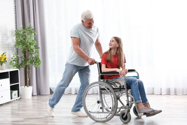 Felice nonno e adolescente in sedia a rotelle a casa — Foto Stock