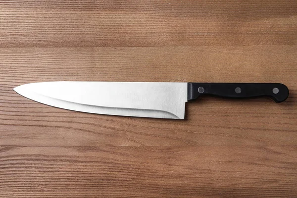 Ahşap masa üzerinde keskin şef bıçağı, üst görünümü — Stok fotoğraf