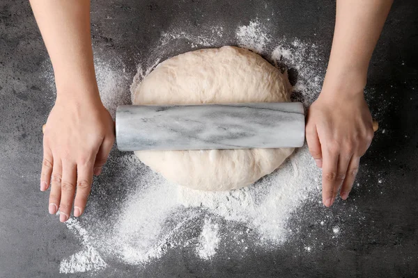 Женщина-пекарь готовит тесто для хлеба на сером столе, вид сверху — стоковое фото