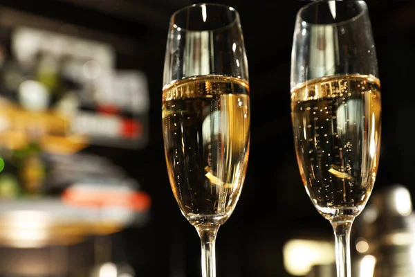 Glasses of champagne in bar, low angle view. Space for text