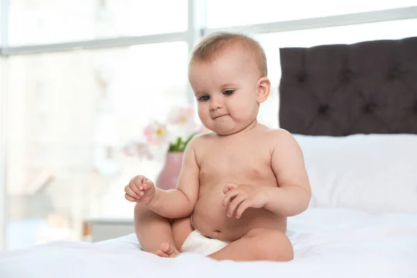 Carino bambino in pannolino sul letto a casa — Foto Stock