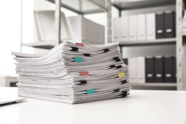Ofis masasında ataçiçeren belge yığını. Metin için alan