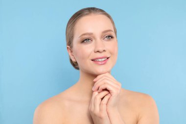 Mavi arka planda güzel yüzlü genç kadının portresi