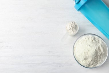 Beyaz ahşap masa üzerinde protein tozu ile düz yatıyordu kompozisyon, metin için alan