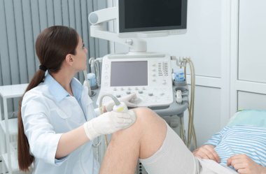 Hastanın diz iletken ultrason muayenesi kliniğinde doktor
