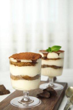 Masa üzerinde tiramiisu kek ve çikolata iki bardak kompozisyon