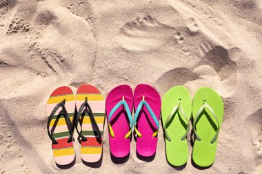 Yaz aylarında kum üzerinde flip flop ile Düz yatıyordu kompozisyon, metin için alan. Plaj aksesuarları
