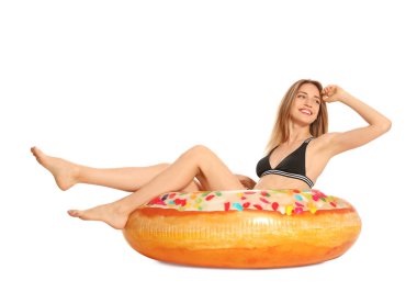 Beyaz arka planda çörek şişme halka ile şık bikini güzel genç kadın