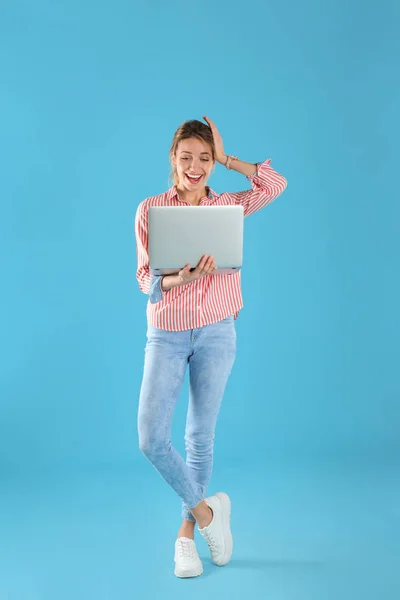 Portrait complet de jeune femme surprise en tenue décontractée avec ordinateur portable sur fond de couleur — Photo