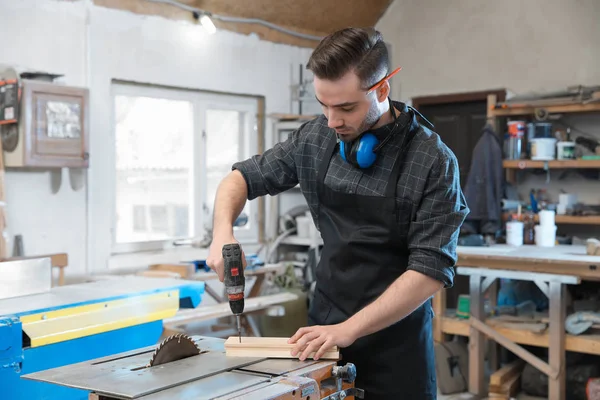 Jonge werkende man met elektrische schroevendraaier bij Carpentry Shop — Stockfoto