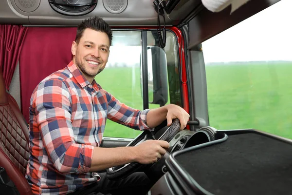 Профессиональный водитель сидит в кабине современного грузовика — стоковое фото