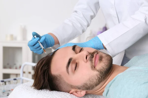 Young man with hair loss problem receiving injection in salon — Stock Photo, Image