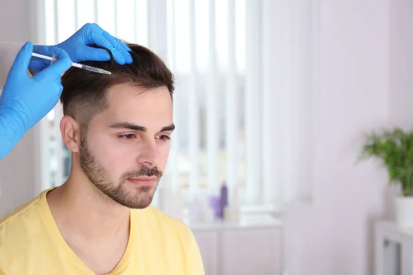 Hombre joven con problemas para perder el cabello recibiendo la inyección en el salón —  Fotos de Stock