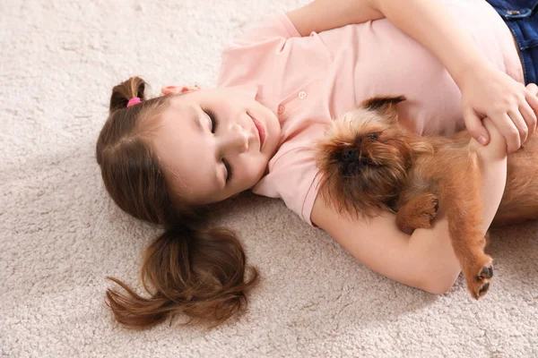 Portrait de fille mignonne avec drôle de chien Griffon de Bruxelles couché sur le tapis. Des amis loyaux — Photo