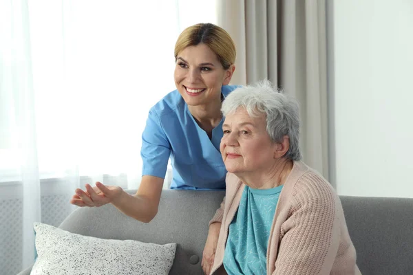 Verpleegkundige met oudere vrouw binnenshuis. Assisteren van ouderen — Stockfoto