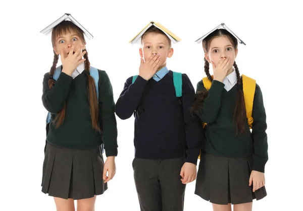 Portré vicces gyerekek az iskolában egységes a könyveket a fej ellen, fehér háttér — Stock Fotó