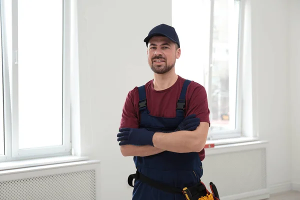 Porträtt av professionell byggnadsarbetare med verktygsbälte inomhus — Stockfoto