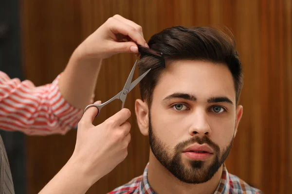Barbiere che fa taglio di capelli elegante con forbici professionali nel salone di bellezza — Foto Stock