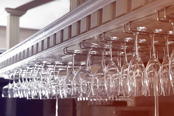 Set of empty clean glasses on bar racks — Stock Photo, Image