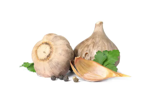 Aged black garlic with parsley on white background — Stock Photo, Image