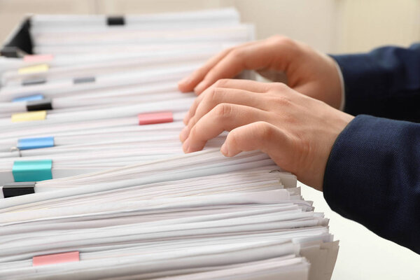 Женщина работает с документами в офисе, крупным планом
